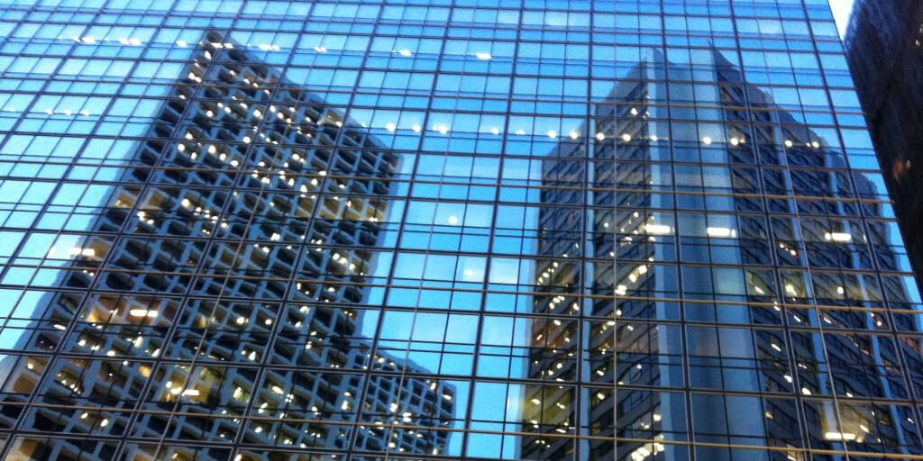 Reflections of skyscrapers in the glass windows of another skyscraper